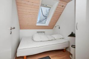 a bed in a small room with a window at 40172-Juelsminde-Strandengen-30 in Juelsminde