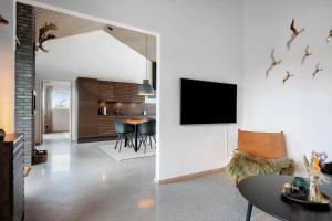 a living room with a table and a tv on a wall at 30477-Odder-Strandvaenget-2 in Odder