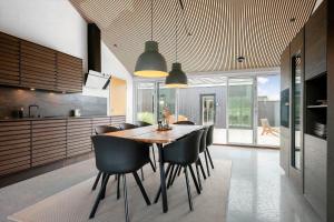 a kitchen and dining room with a wooden table and chairs at 30477-Odder-Strandvaenget-2 in Odder