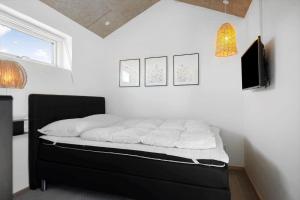 a bedroom with a bed with white sheets and a window at 30477-Odder-Strandvaenget-2 in Odder