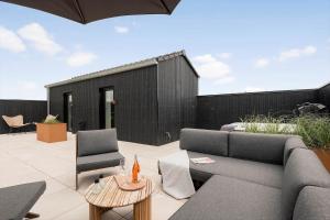a patio with a couch and a table and chairs at 30477-Odder-Strandvaenget-2 in Odder