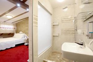 un bagno con lavandino e doccia e un letto di Hotel Lula a Sarajevo
