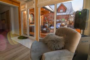 a living room with a chair and a television at Apartament Tatry One in Zakopane