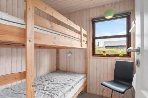 a bedroom with two bunk beds and a chair at 40607-Juelsminde-Pilevaenget-16 in Juelsminde +23 photos