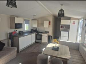 a kitchen and living room with a couch and a table at 3 bed Caravan wink ups towyn in Kinmel Bay