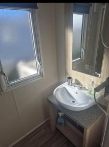 a bathroom with a sink and a window at 3 bed Caravan wink ups towyn in Kinmel Bay