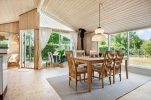 a dining room with a wooden table and chairs at 30415-Odder-Strandparksvej-50 in Odder