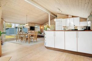 a kitchen and dining room with white cabinets and a table at 30415-Odder-Strandparksvej-50 in Odder +20 photos