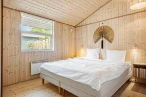 a bedroom with a large white bed with a window at 30415-Odder-Strandparksvej-50 in Odder