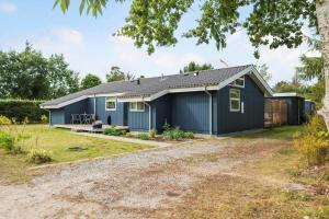 a home with a blue house with a yard at 30415-Odder-Strandparksvej-50 in Odder