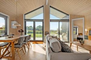 a dining room and living room with a table and chairs at 30427-Saksild-Strandvaenget-31 in Saksild