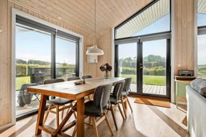 a dining room with a wooden table and chairs at 30427-Saksild-Strandvaenget-31 in Saksild +21 photos