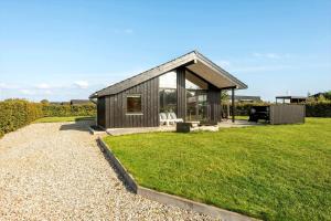 a small wooden house with a grass yard at 30427-Saksild-Strandvaenget-31 in Saksild
