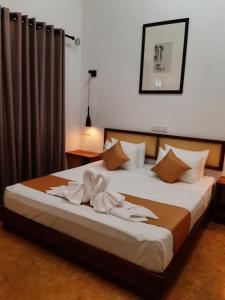 a bedroom with a bed with towels on it at Villa AyuSri in Ambalangoda