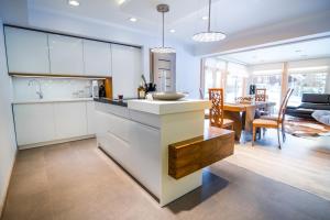 a kitchen with white cabinets and a dining room at Apartament Tatry One in Zakopane