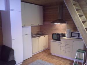 a kitchen with a white refrigerator and a microwave at Vipati Cottage in Ylitornio