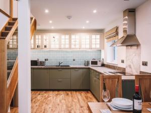 a kitchen with green cabinets and a wooden table at An Dobhran - Ukc5752 in Dornie +14 photos