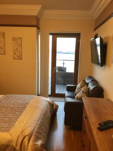 1 dormitorio con cama, sofá y TV en Thornbank House, en Stranraer