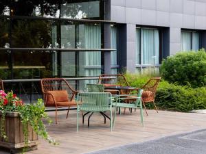 a group of chairs and a table in front of a building at ibis Styles Lille Aéroport in Lesquin