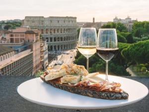 a plate of food and two glasses of wine at Mercure Roma Centro Colosseo in Rome