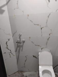a bathroom with a white toilet and a sink at Hotel Rajpal in Jaipur