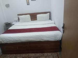 a bedroom with a large bed with a wooden headboard at Hotel Rajpal in Jaipur