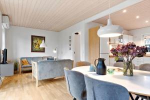 a dining room and living room with a table and chairs at 40173-juelsminde-Strandengen-46 in Juelsminde