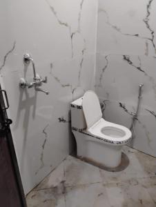 a bathroom with a white toilet in a room at Hotel Rajpal in Jaipur