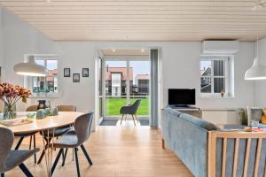 a living room with a blue couch and a table at 40173-juelsminde-Strandengen-46 in Juelsminde