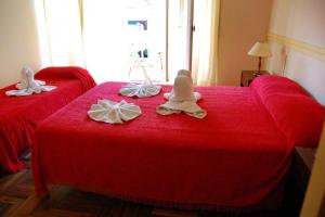 
a bed with a red blanket on top of it at Hotel del Paseo in Mar del Plata
