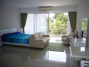 a bedroom with a bed and two chairs and a desk at Chic Condominium Unit A303, A306, A307, A308, A406 in Karon Beach