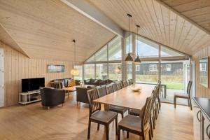 a dining room and living room with a table and chairs at M235-Vaeggerlose-Kaninstien-33 in Bøtø By