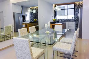 a kitchen with a glass table and chairs at Shamrock Beach Villas 15 Seaview in George Town