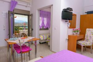 a room with a table and chairs and a bedroom at Villa Minoas Apartments in Istro