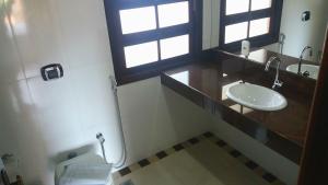 a bathroom with a sink and a toilet and a window at Pousada Normandy in São Lourenço