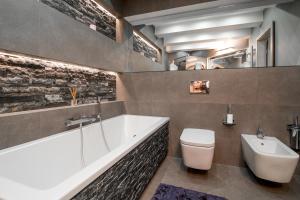 a bathroom with a tub and a toilet and a sink at Apartament Tatry One in Zakopane +41 photos