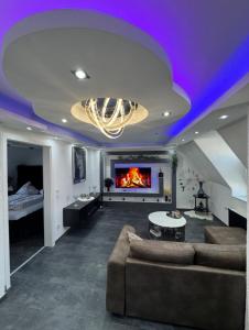 a living room with a couch and a fireplace at Phöenixpalace Whirlpool & Infarotsauna in Dortmund