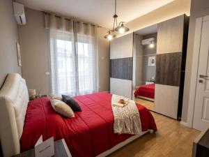 a bedroom with a red bed with a red blanket at Aura Deluxe Apartments in Syracuse