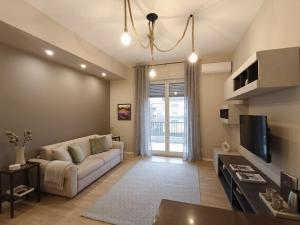 a living room with a couch and a tv at Aura Deluxe Apartments in Syracuse