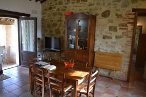 una sala da pranzo con tavolo in legno e TV di Agriturismo Marano a Mengara