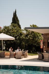 two people sitting in chairs next to a swimming pool at Palacio São Silvestre-Boutique Hotel in Coimbra
