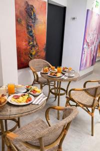 two tables with plates of food in a room at Hotel Monterosa Lofts in Pereira
