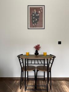 a table with two chairs and a picture on the wall at Cozy Stay Marijampolė in Marijampolė