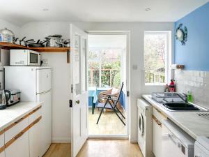 a kitchen with a white refrigerator and a sink at The Castaway in Mundesley