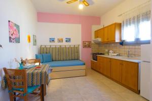 a kitchen with a table and a blue couch in a room at Villa Minoas Apartments in Istron +31 photos