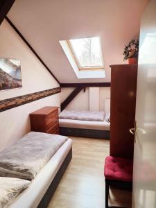 a attic room with two beds and a window at FeWo Hoffmann DG - Ihr Domizil für Arbeit oder Kurzurlaub in Böhlen