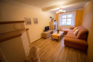 ein Wohnzimmer mit einem Sofa und einem TV in der Unterkunft Ferienwohnung "Beim Nachtwächter" in Görlitz