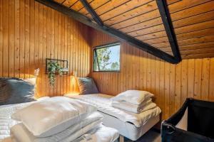 a room with two beds in a wooden wall at M368-Rodby-Spurvevaenget-11 in Rødby