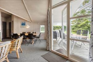 a dining room with a table and chairs and a glass door at M369-Vaeggerlose-Mimosevej-19 in Bøtø By