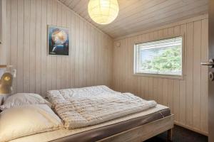a bedroom with a bed in a room with a window at M369-Vaeggerlose-Mimosevej-19 in Bøtø By